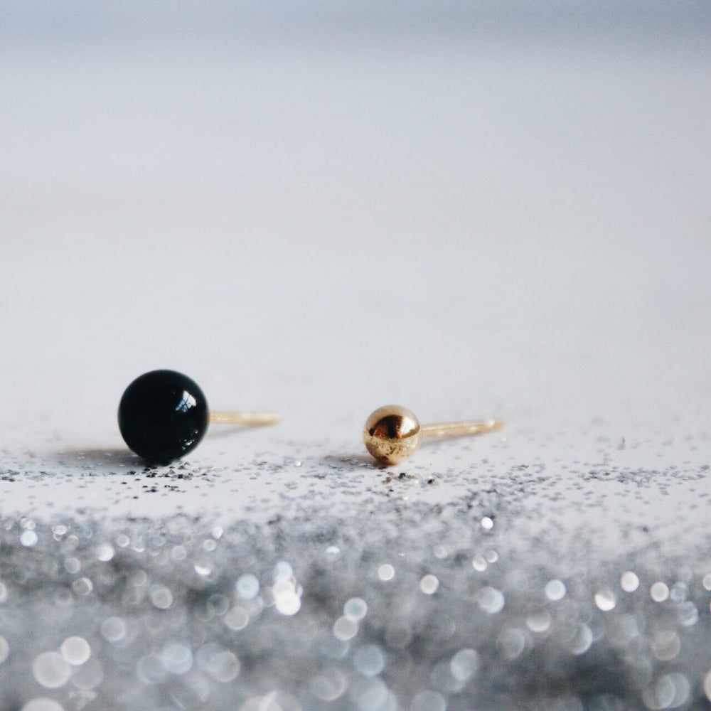 'particulas elementales' - onyx of malachiet met 18kt verguld oorbelletje